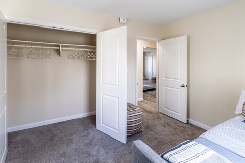 A bedroom with a bed, a wardrobe, and a mirror.