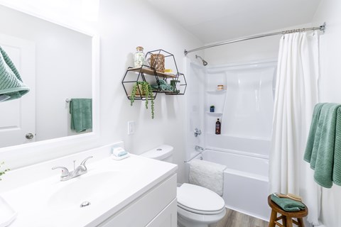 A white bathroom with a white tub and toilet.
