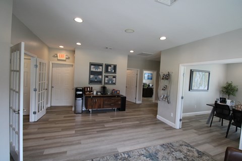 a living room with a wooden floor and white walls and doors