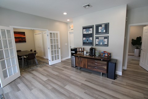 a living room with a wooden floor and a table and chairs