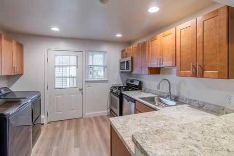 A kitchen with wooden cabinets and a granite countertop.