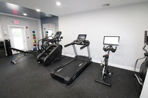 a gym with treadmills and exercise bikes in a building