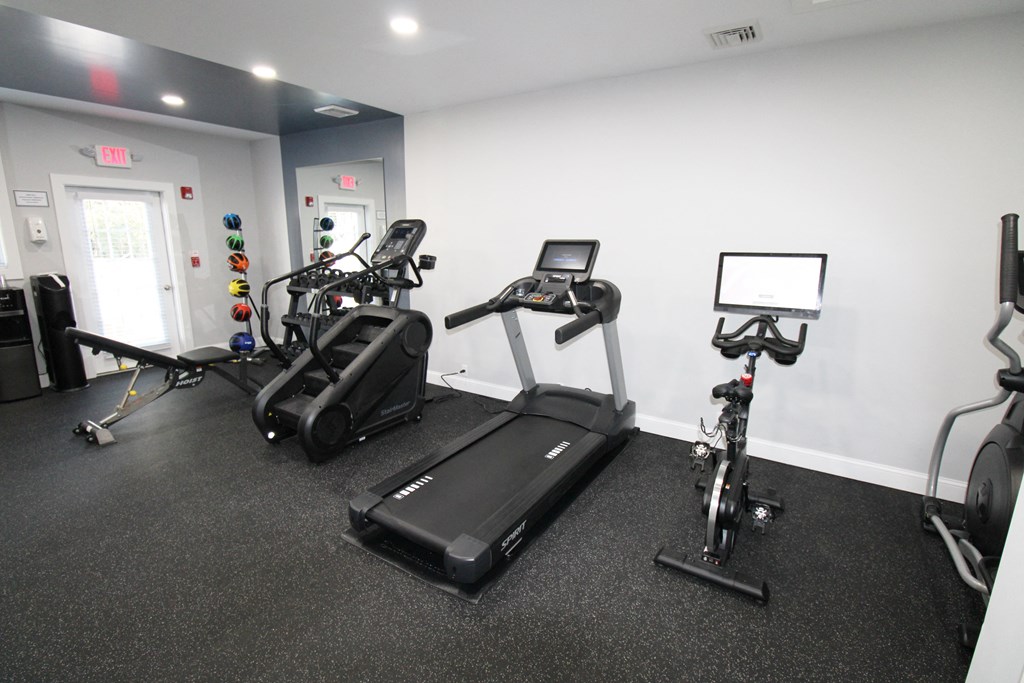 a gym with treadmills and exercise bikes in a building
