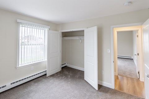 A room with a white door and a window with blinds.