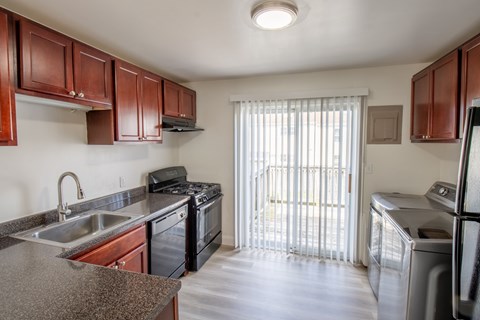 A kitchen with brown cabinets and a black stove top oven.