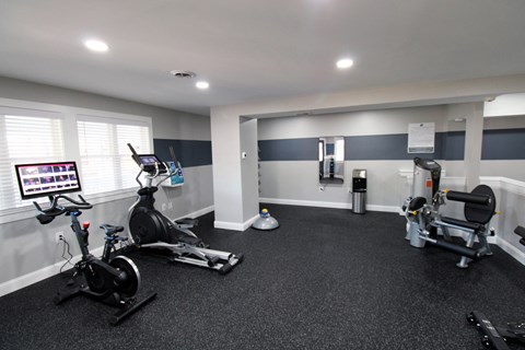 a home gym with exercise equipment and a large window