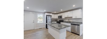 A kitchen with a granite countertop and stainless steel appliances.