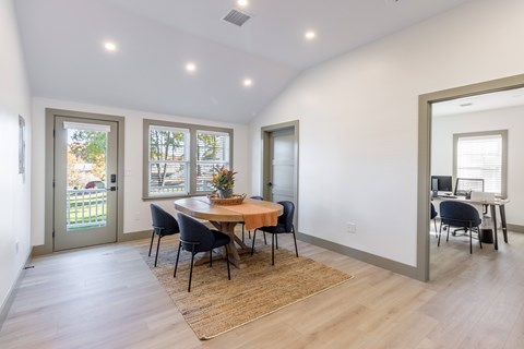 A dining room with a table and chairs.