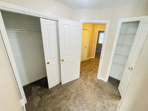 a bedroom with three closets and a carpeted floor