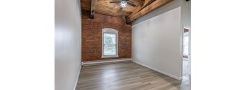 A room with a brick wall and a ceiling fan.