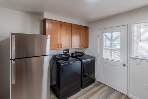 A kitchen with a stainless steel refrigerator and black dishwasher.