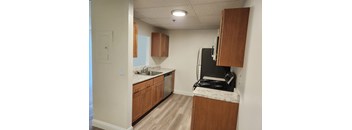 A kitchen with wooden cabinets and a black stove top.