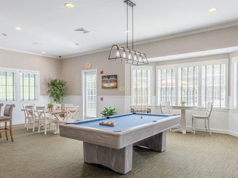 a room with a pool table and a dining room