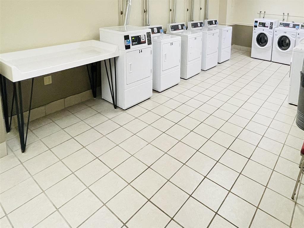 a row of washers and dryers in a laundry room