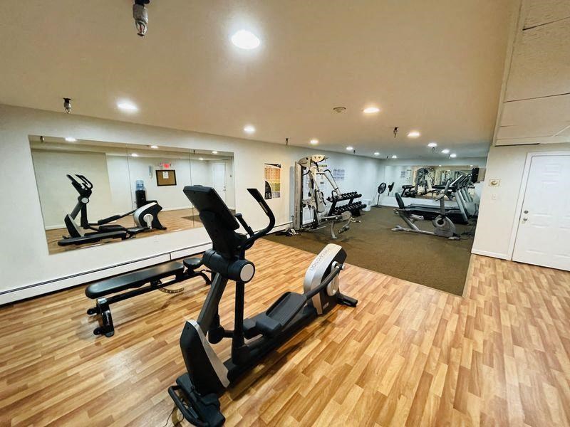 a gym with exercise equipment on a wooden floor