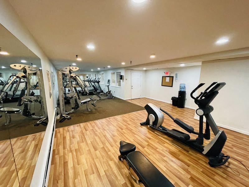 a gym with exercise equipment on a wooden floor