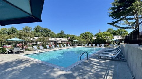 a swimming pool with chairs and chairs around it