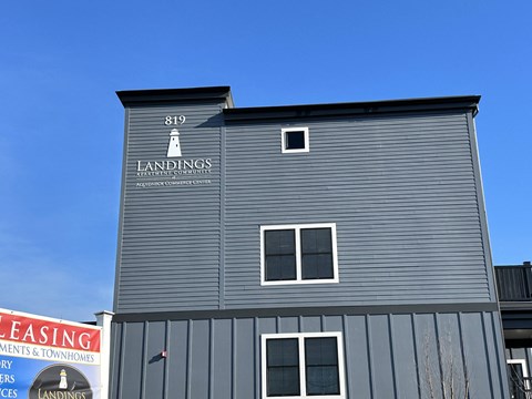 A grey building with a sign that says Landings on it.
