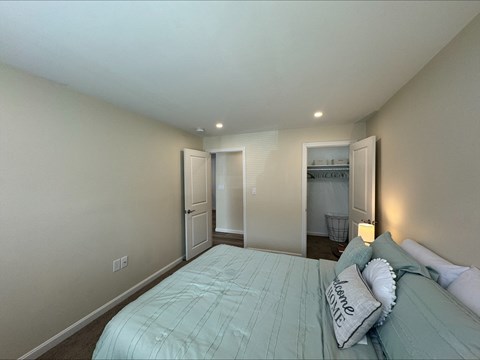 A bedroom with a bed and a nightstand.