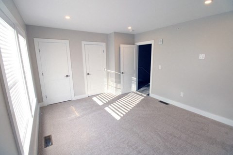 A room with white doors and a carpeted floor.
