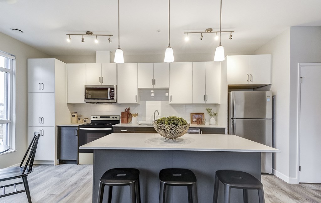Kitchen with white cabinets and a large island at 101 Base Line Road West, London