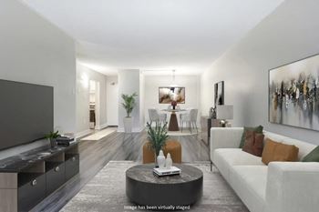 Living room with white furniture and a tv  at Platts Crossing, London, ON, N6H 4P4