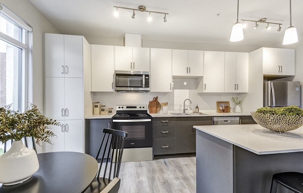 Kitchen with white cabinets and black appliances and a table and chairs  at 101 Base Line Road West, Ontario