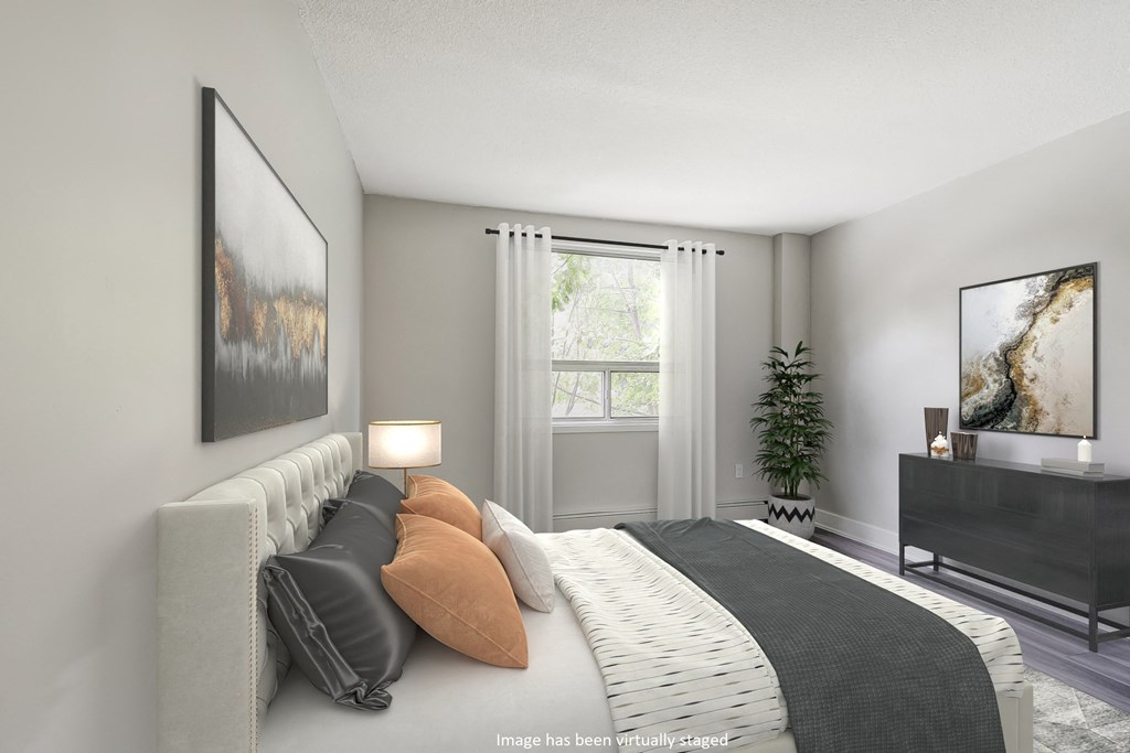 Bedroom with grey walls and a large bed Bedroom with grey walls and a large bed with brown and white pillows at Platts Crossing, London, ON