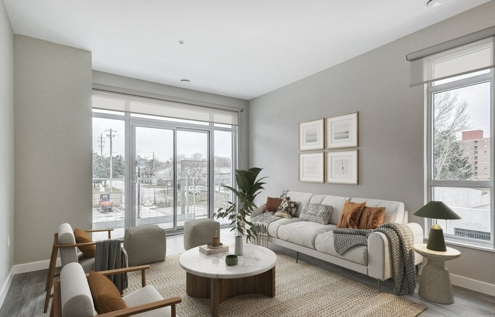 Living room with a white couch and a large window  at 101 Base Line Road West, London, ON