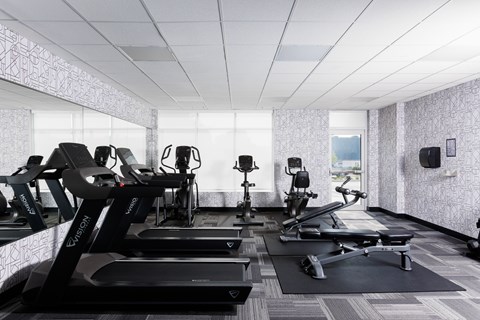 A gym with treadmills, exercise bikes, and other equipment at 1600 Hyde Park Village Apartments, London