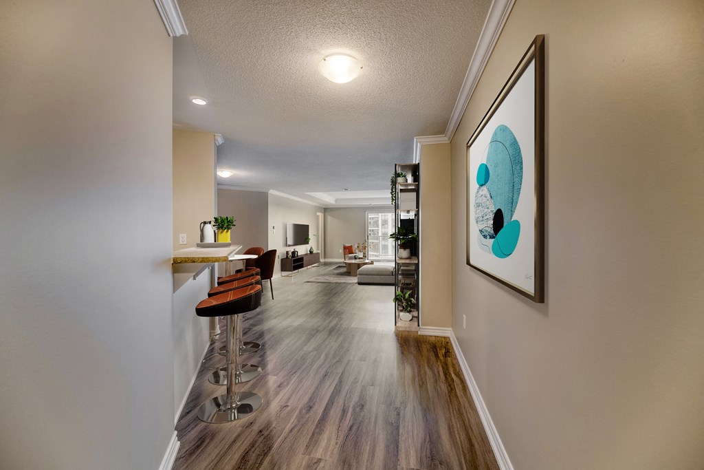 a kitchen and living room with hardwood flooring and a painting on the wall