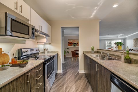 an open kitchen with stainless steel appliances and marble counter tops