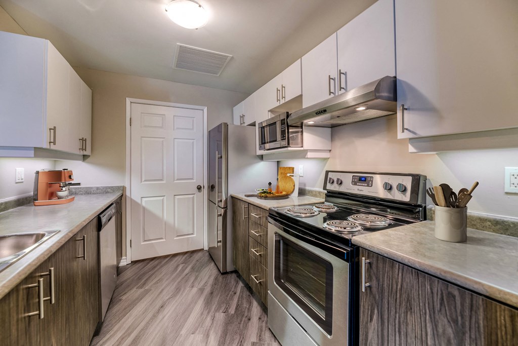 a kitchen with white cabinets and stainless steel appliances