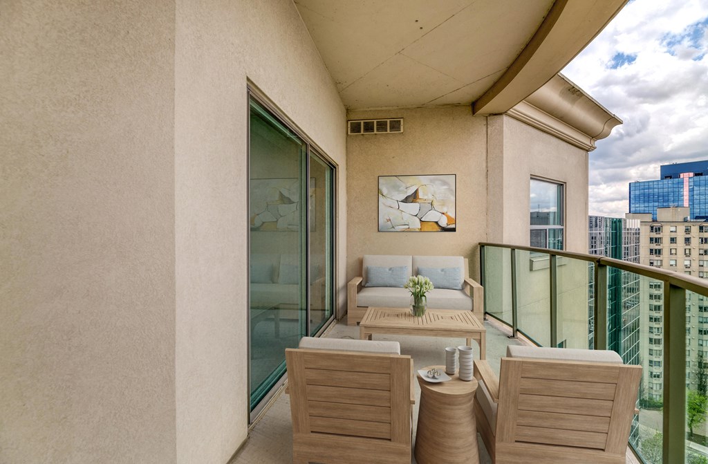 a balcony with a couch a table and two chairs