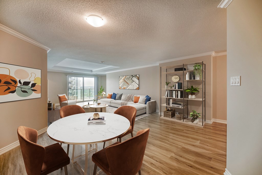 a dining area with a round table and chairs and a living room