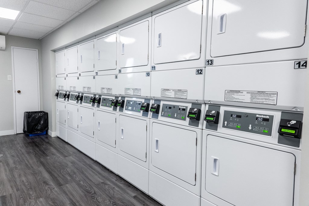 a row of washers and dryers in a utility room