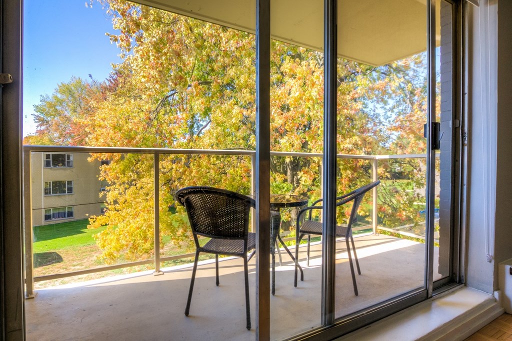 a balcony with a table and two chairs and a large window