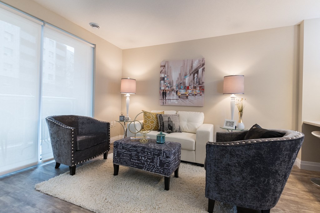 a living room with a white couch and two black chairs