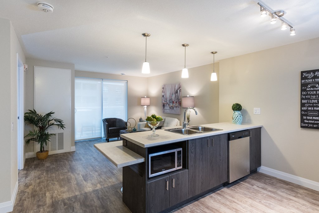 a kitchen with an island and a living room in the background