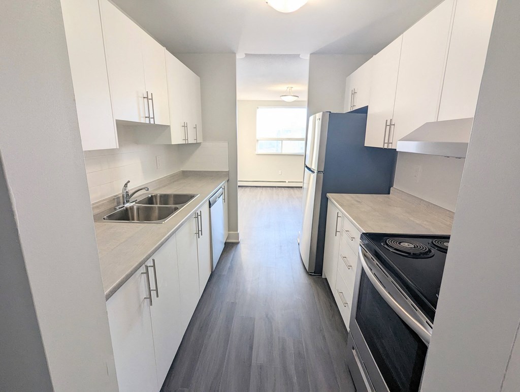 a kitchen with white cabinets and a black stove top oven