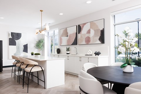 A modern kitchen with a dining table and chairs.