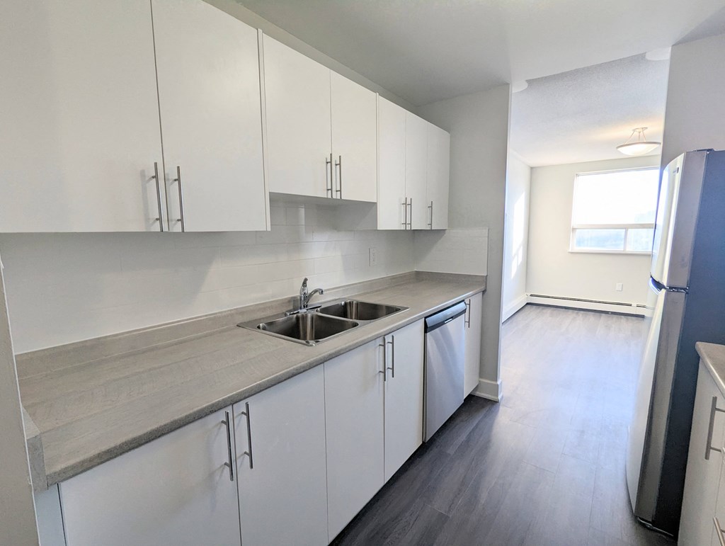 a kitchen with white cabinets and a stainless steel sink