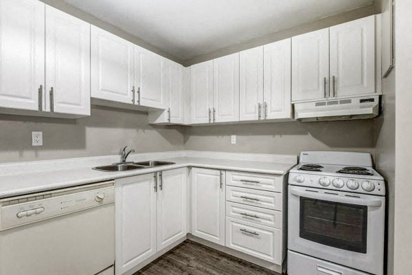 a kitchen with white cabinets and white appliances