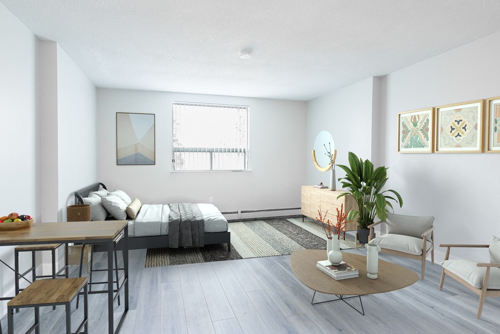 A modern bedroom with a bed, a chair, a table, and a potted plant.