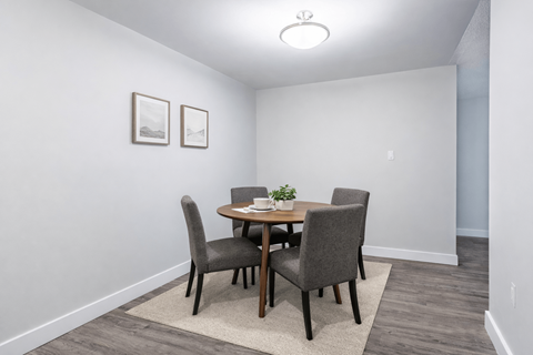 A dining room with a table and chairs.