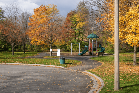 A playground with a green slide and a white sign.