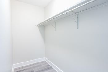 A white wall with a white shelf and a white floor.