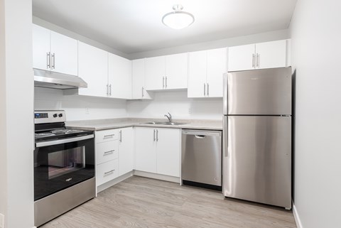 A modern kitchen with stainless steel appliances and white cabinets.