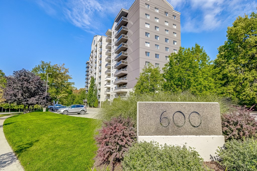 a large stone sign with the number 60 on it in front of an apartment building
