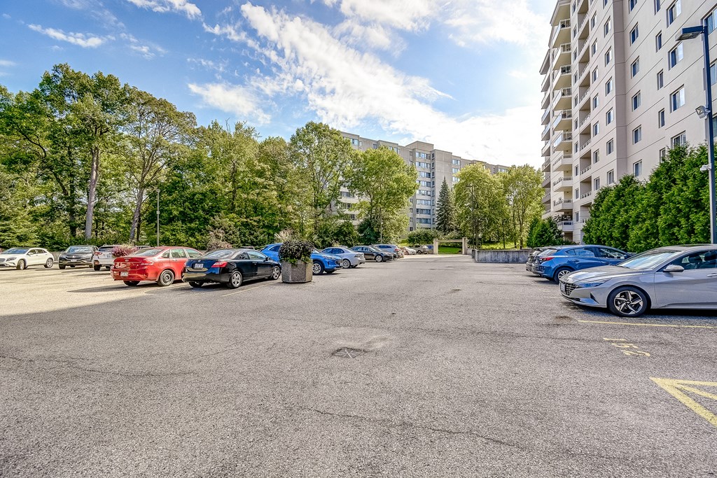 a parking lot with cars parked in front of an apartment building